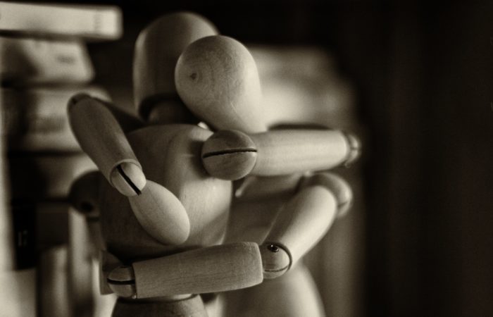Two wooden dolls embracing each other