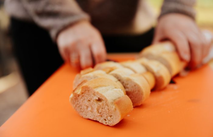 a woman cutting French bread into slices