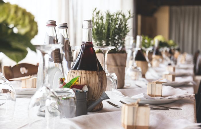 A wine carafe on a table next to water bottles at a wedding banquet
