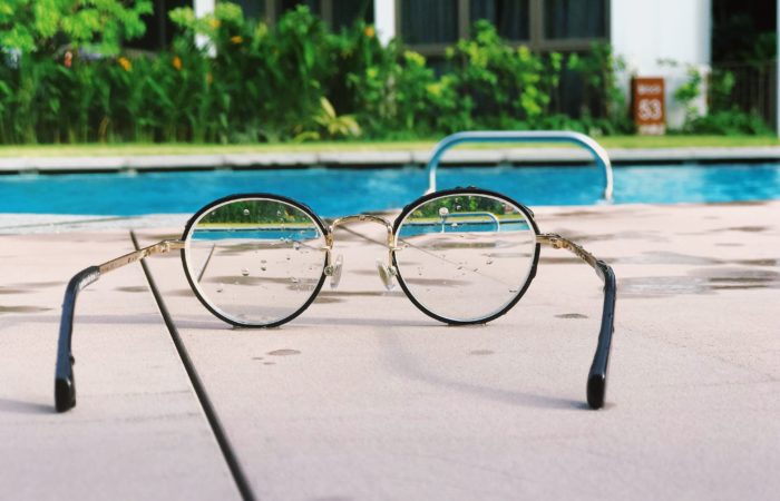 A set of eyeglasses by a swimming pool