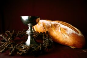 A Communion chalice, a loaf of bread, and a crown of thorns