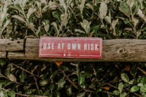 A piece of wood with a sign on it that says "USE AT OWN RISK"