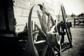 A broken down wooden cart in a field