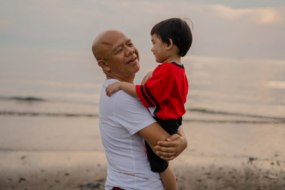 An older man holding a toddler boy in his arms